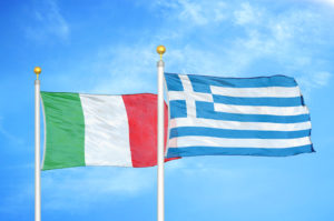 Italy and Greece two flags on flagpoles and blue cloudy sky